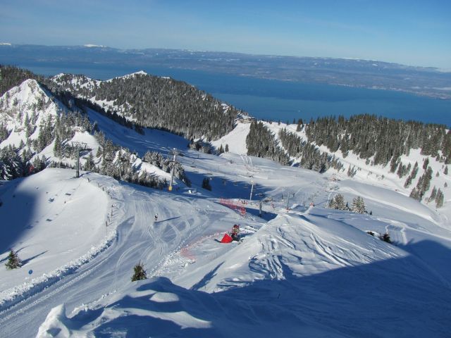 Paysage dans les Alpes où les jeunes en colo de vacances dévalent les pistes de ski 