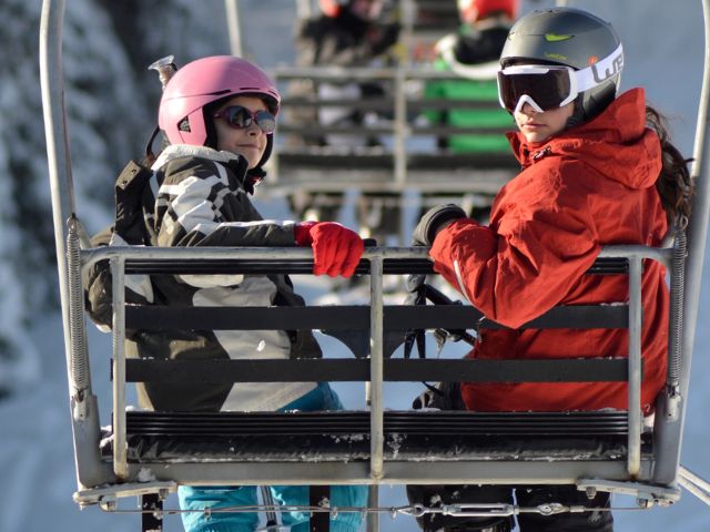 Jeunes en colonie de vacances Ski cet hiver qui s'amusent sur le télésiège 