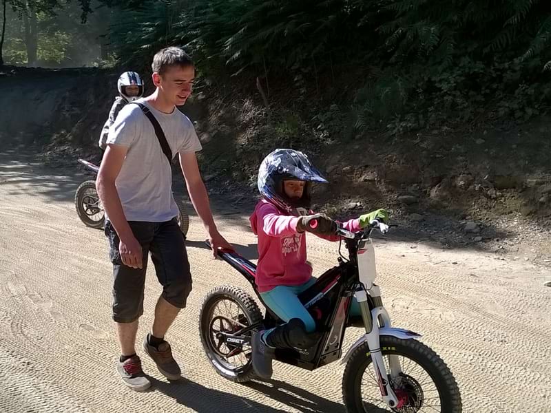 enfant apprenant à faire de la moto électrique en colonie de vacances