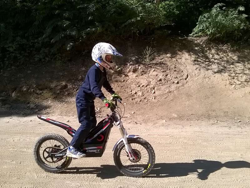 jeune enfant apprenant à conduire une moto électrique en colo