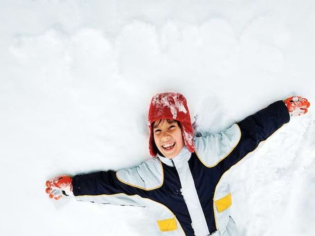 Enfant allongé dans la neige 