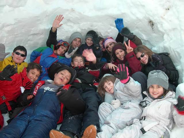 Groupe d'enfants en colo dans la neige