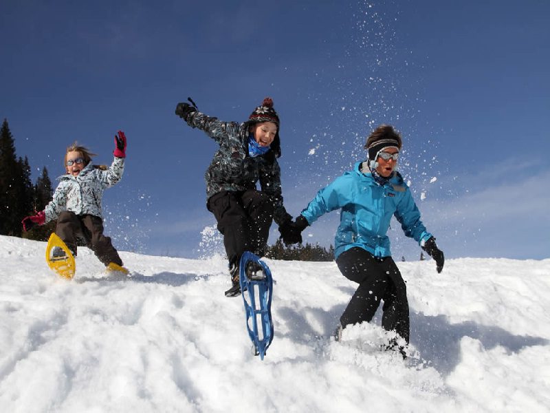 Enfants courant dans la neige en raquettes