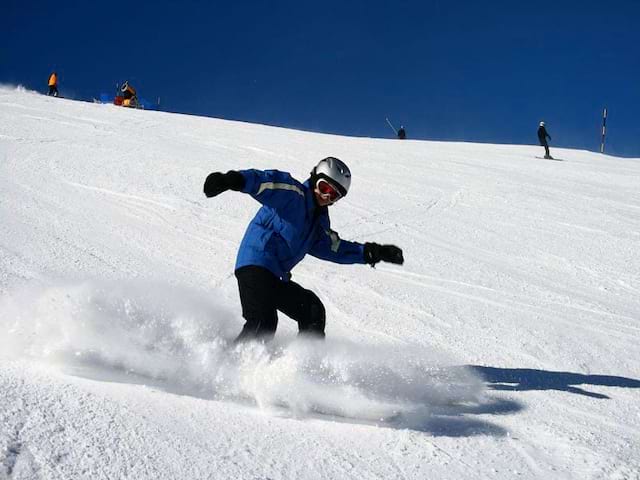 enfant faisant du snowboard en colonie cet hiver