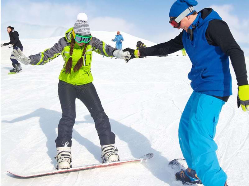 ados apprenant à faire du snowboard en colonie de vacances cet hiver