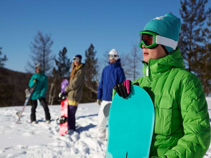 Ados avec leur planche de snow en colonie de vacances à Courchevel l'hiver