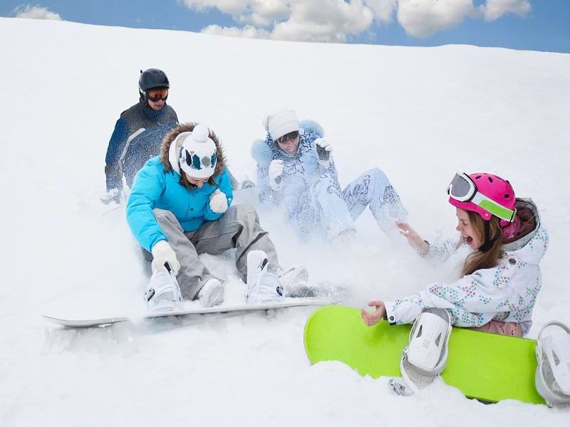 adolescents jouant dans la neige cet hiver pendant une colo de snowboard