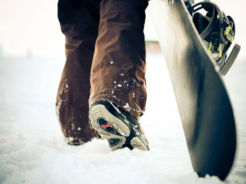 Ado et sa planche de snowboard en colo cet hiver