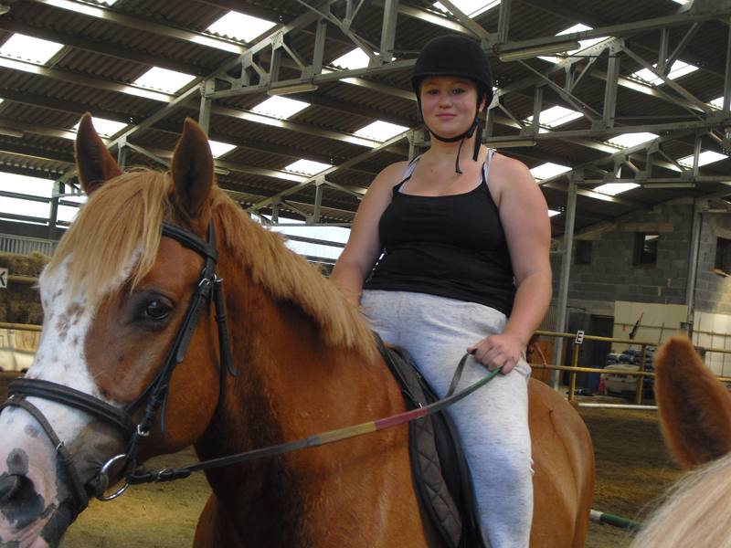 Jeune ado sur le dos de son cheval en colonie de vacances