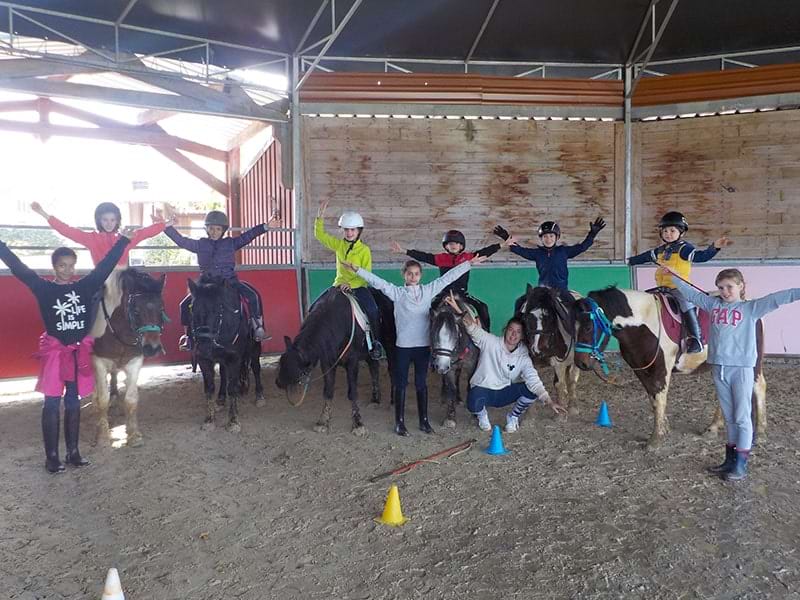 Enfants en colo de vacances équitation à Noel dans le manège équestre