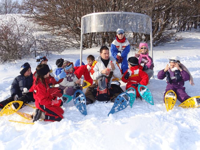 Jeunes en colo de vacances cet hiver qui font des raquettes dans la neige