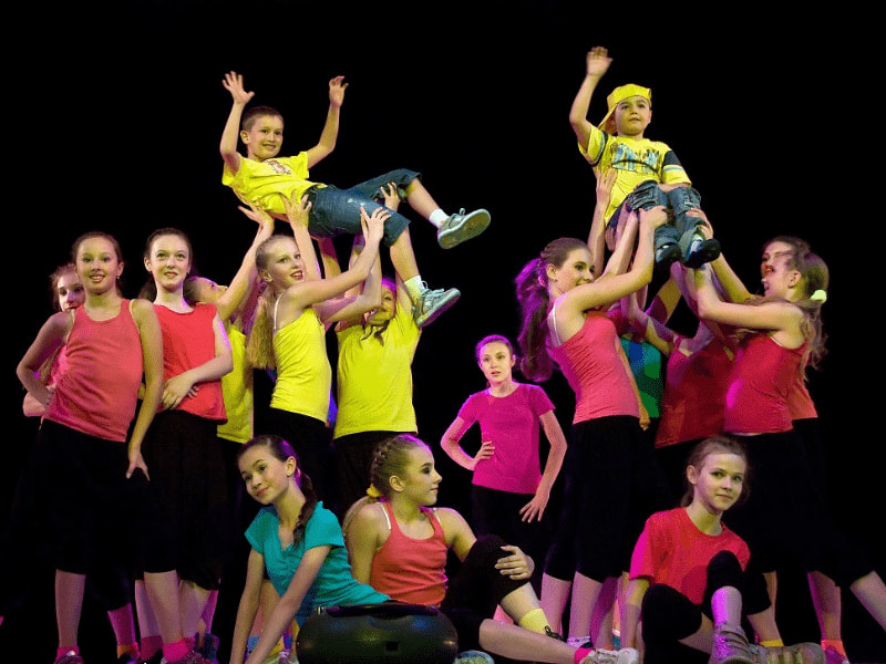 Groupe de jeunes durant un spectacle sur scène en colo de vacances