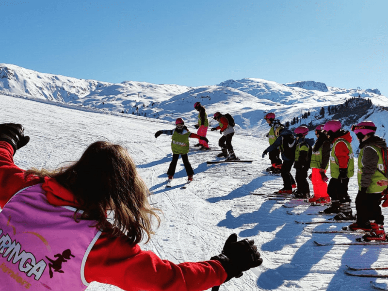Enfants en colo de vacances ski qui apprennent le ski durant Noel