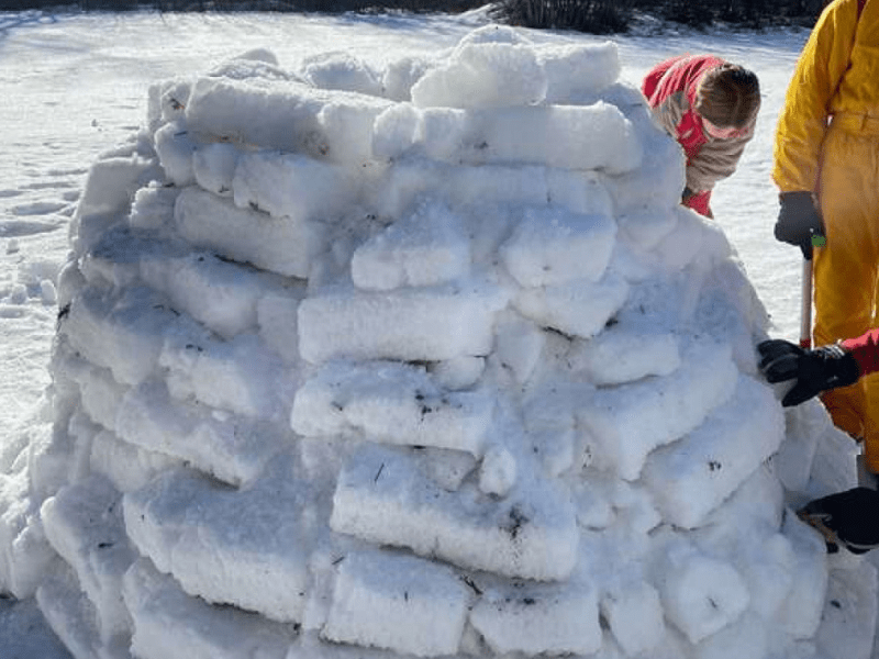 Enfants qui construisent leur propre igloo en colo de vacances Ski de Noel