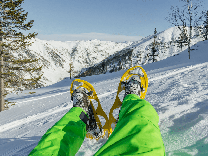 Vue sur un jeune en colo qui a chaussé ses raquettes de neige durant sa colo de vacances