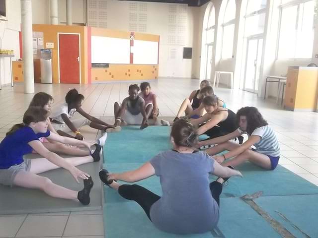 groupe d'enfants faisant des étirement en colonie de vacances de danse