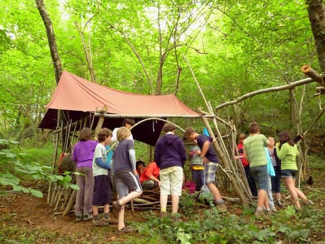 Enfants en train de construire une cabane en colonie de vacances