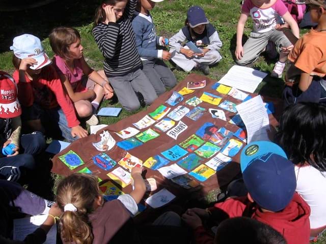 Groupe d'enfants en train de jouer à un jeu de société dans l'herbe