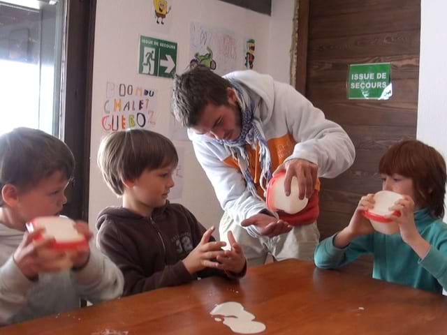 Enfant et animateur en train de faire la cusiine