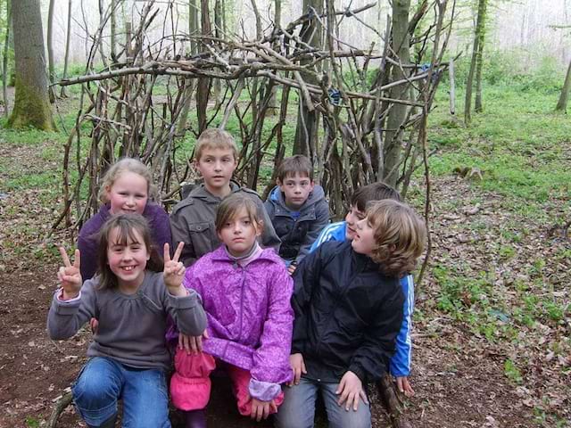 Enfants devant une cabane construite par leurs soins