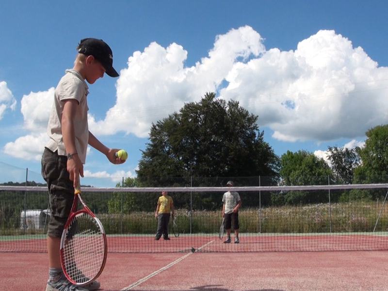 Enfant jouant au tennis en colo 