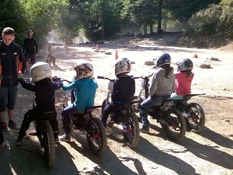 Groupe d'enfants apprenant à conduire une moto en colo
