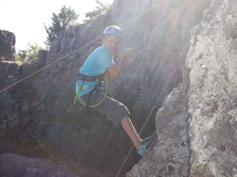 Enfant sur un mur d'escalade en colonie de vacances