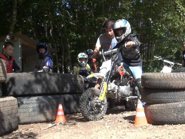 Enfant apprenant à faire de la moto sur terrain de moto cross en colo 