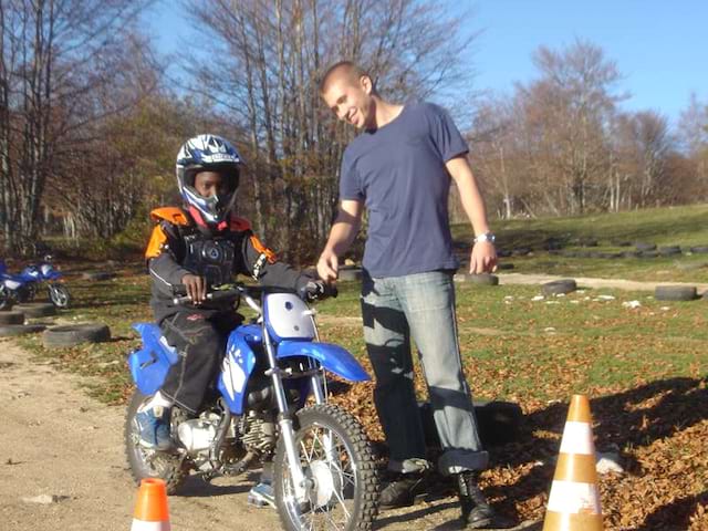 Enfant apprenant à conduire une moto cross en colo