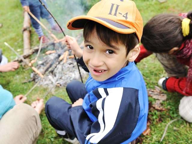 Enfants autour du feu de camp en colonie de vacances