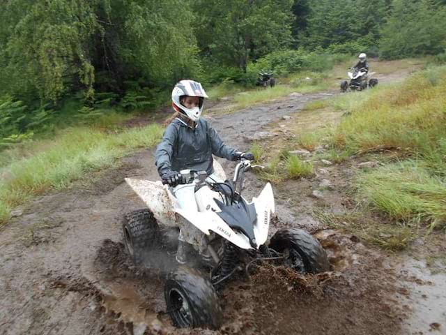 enfant conduisant un quad dans un bourbier en colonie de vacances printemps