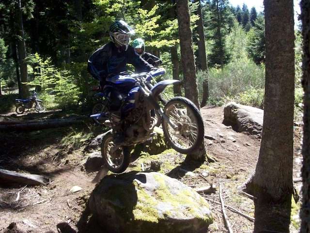 ado faisant de la moto en forêt en colonie