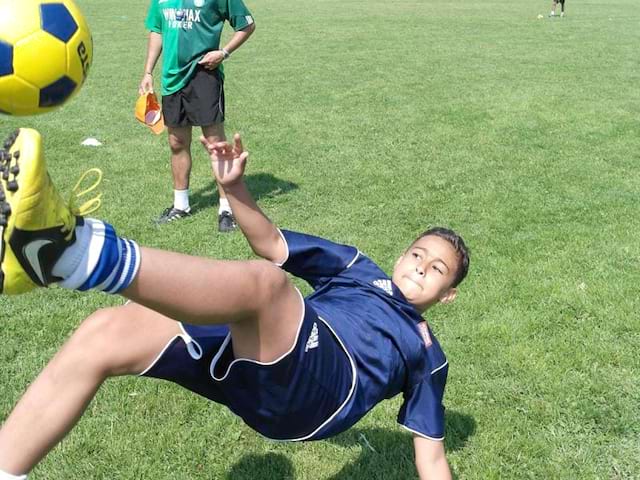 ado jouant au football en colonie de vacances de printemps