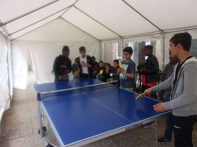 ados autour d'une table de ping pong en colonie de vacances 