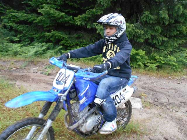 Enfant apprenant à faire de la moto cross en colonie de vacances