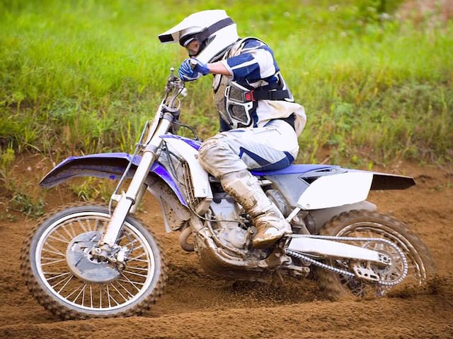 jeune ado faisant de la motocross en colo quad et moto