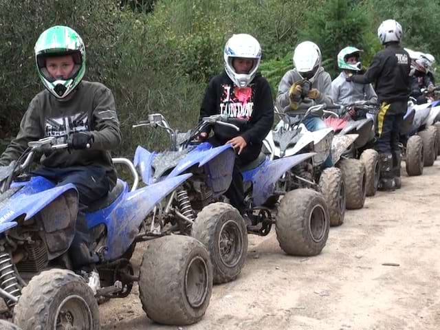 Groupe d'enfants en colonie de vacances faisant une balade en quad