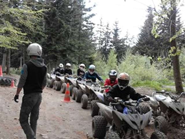 Enfants et ados en randonnée en quad en colonie de vacances d'été