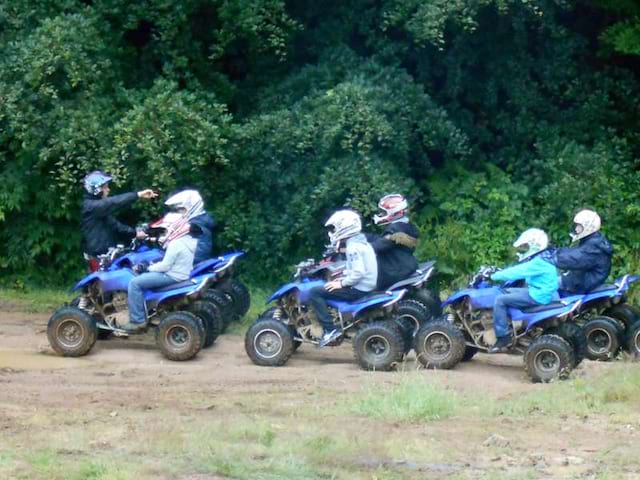 Adolescents conduisant un quad en balade en colonie de vacances d'été 