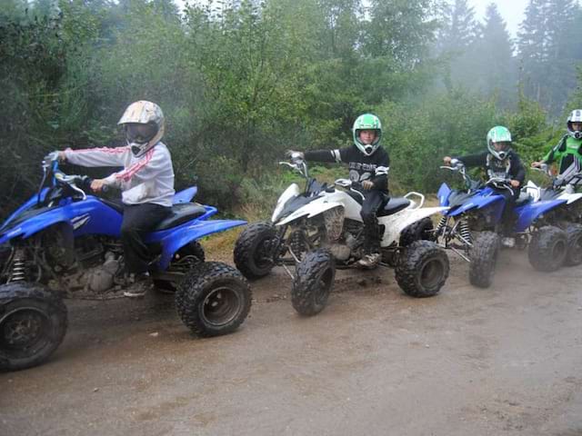 Groupe d'ados et enfants en colo faisant du quad