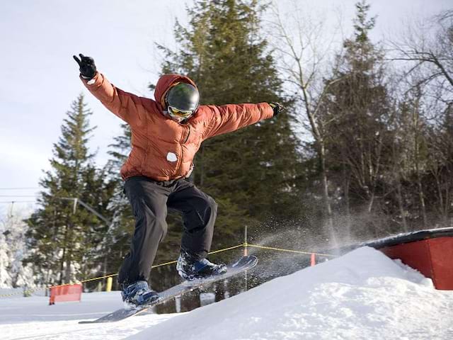 Enfant pratiquant le snowboard en colonie de vacances à Courchevel