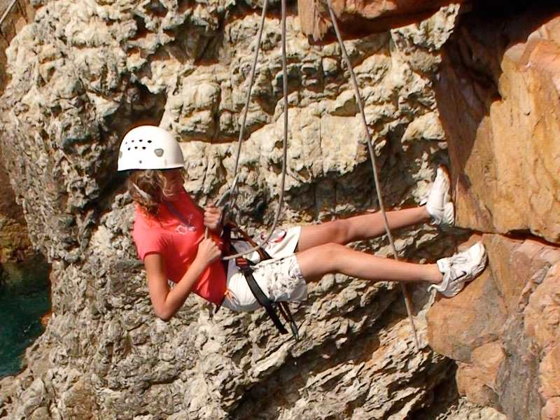 Jeune fille pratiquant l'escalade en colonie de vacances à Monistrol