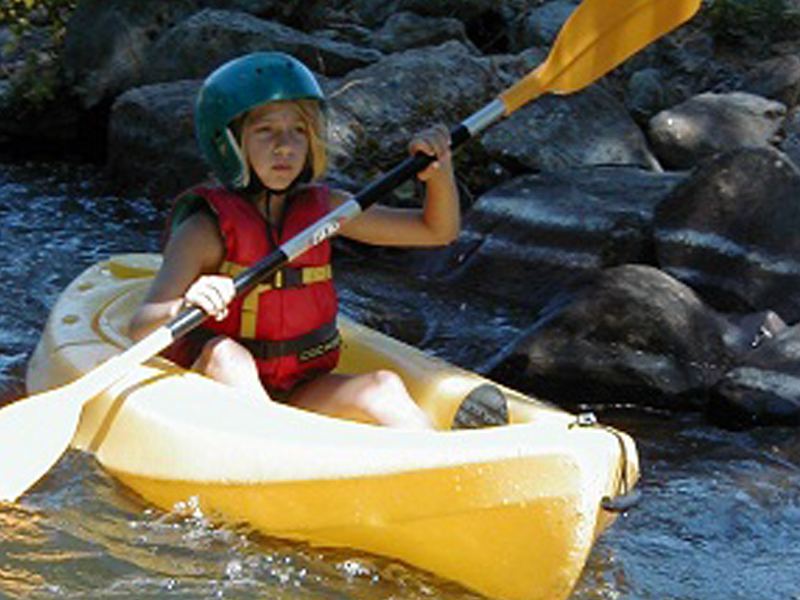 Jeune fille en kayak en colonie de vacances