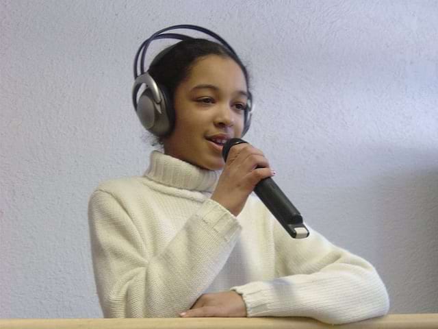 jeune fille avec un casque de musique et un micro apprenant à chanter