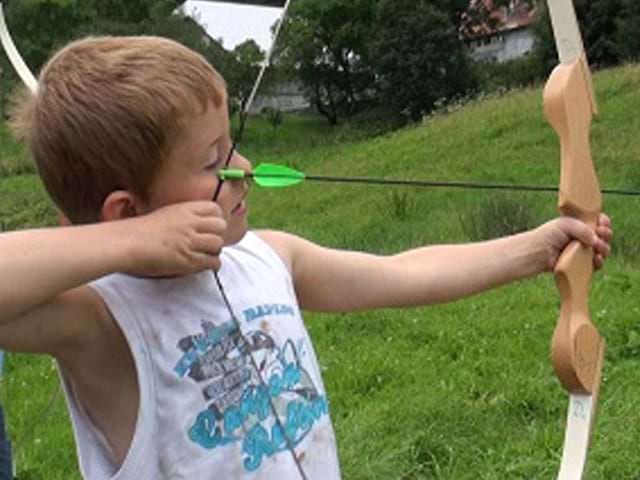 enfant faisant du tir à l'arc en colo au printemps