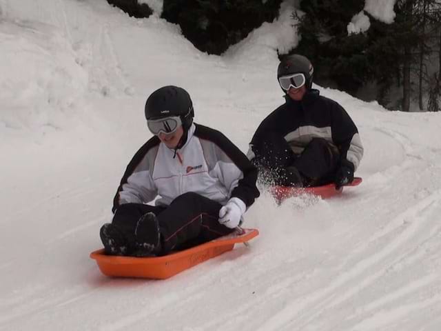 Enfants faisant de la luge en colonie de vacances