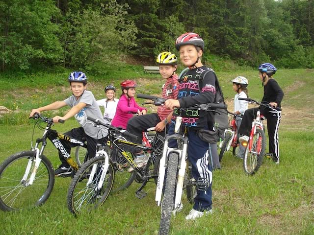 Enfants faisant du vélo à la campagne en colonie de vacances