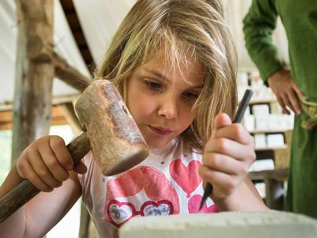 fillette apprenant à tailler la pierre en colo médiévale cet été