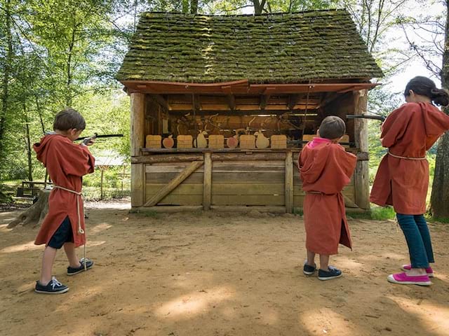 enfants apprenant à tirer à la carabine comme au moyen age cet été en colonie de vacances