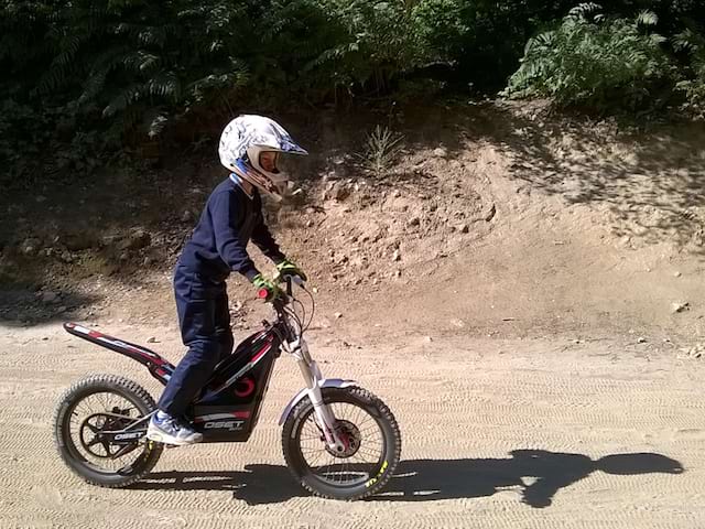 Enfant en colonie de vacances apprenant à faire de la moto